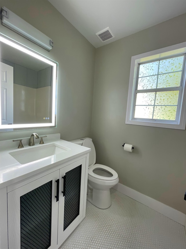 bathroom with vanity, toilet, and tile patterned flooring