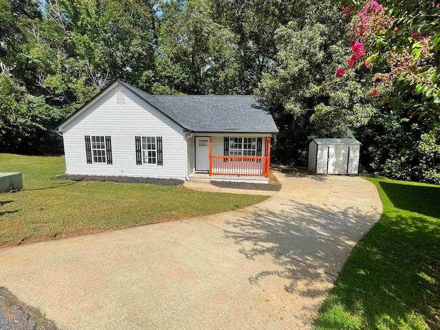 ranch-style house featuring a storage unit and a front yard