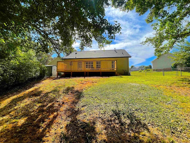 rear view of house featuring a lawn and a deck