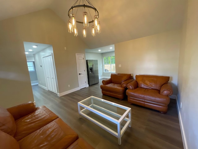 living room with dark wood-type flooring, high vaulted ceiling, and a chandelier