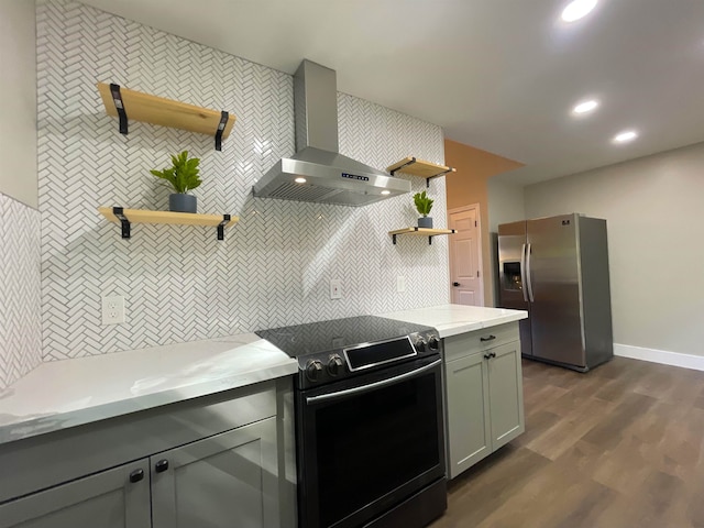 kitchen with wall chimney exhaust hood, dark hardwood / wood-style flooring, stainless steel refrigerator with ice dispenser, electric range, and gray cabinets