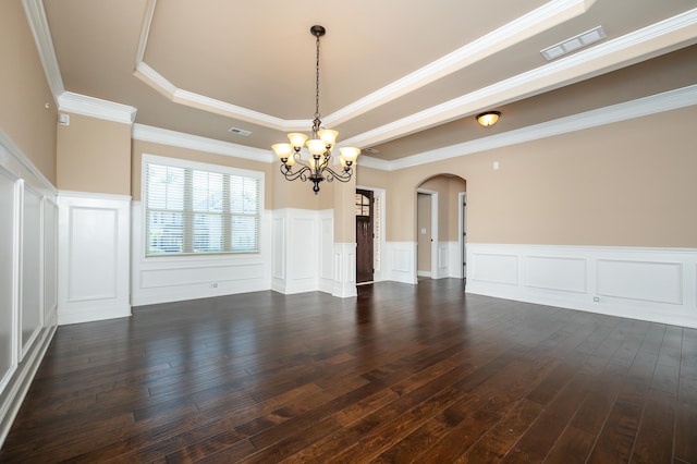 unfurnished room with a tray ceiling, dark hardwood / wood-style flooring, ornamental molding, and an inviting chandelier