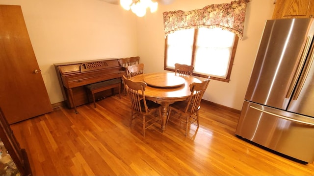 dining area with baseboards and light wood-style floors