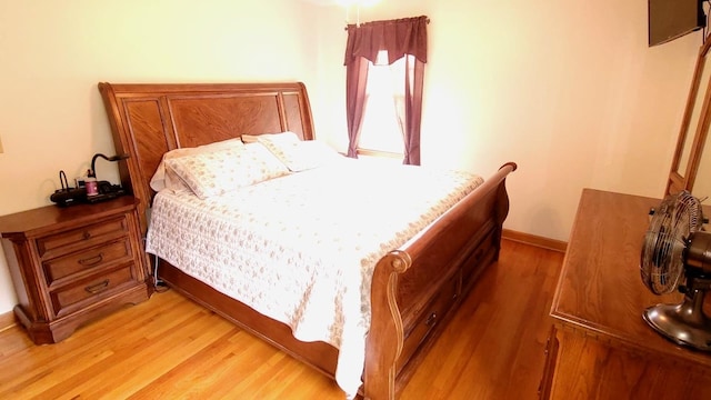 bedroom featuring baseboards and light wood finished floors