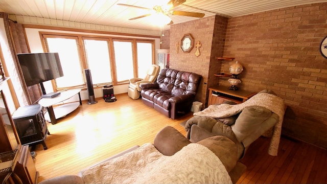 living area with hardwood / wood-style floors, wood ceiling, brick wall, and a ceiling fan