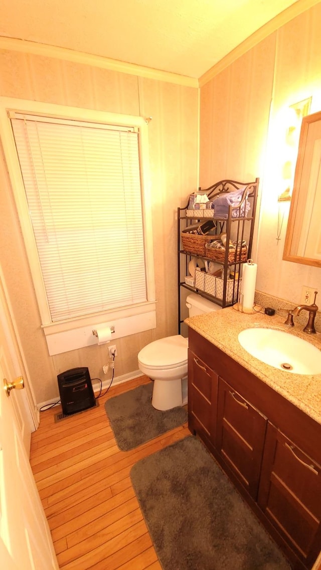 bathroom featuring crown molding, toilet, vanity, and wood finished floors