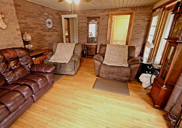 living room featuring ceiling fan, light hardwood / wood-style floors, brick wall, and wooden ceiling