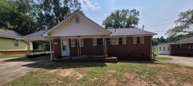view of front of house with an attached carport, a front yard, brick siding, and driveway