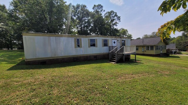 rear view of house with crawl space and a lawn