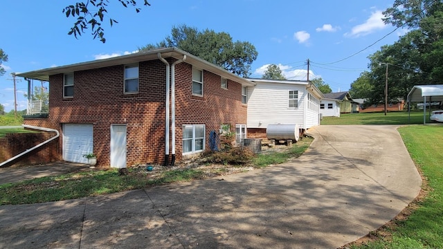 exterior space featuring brick siding, a lawn, driveway, and a ceiling fan