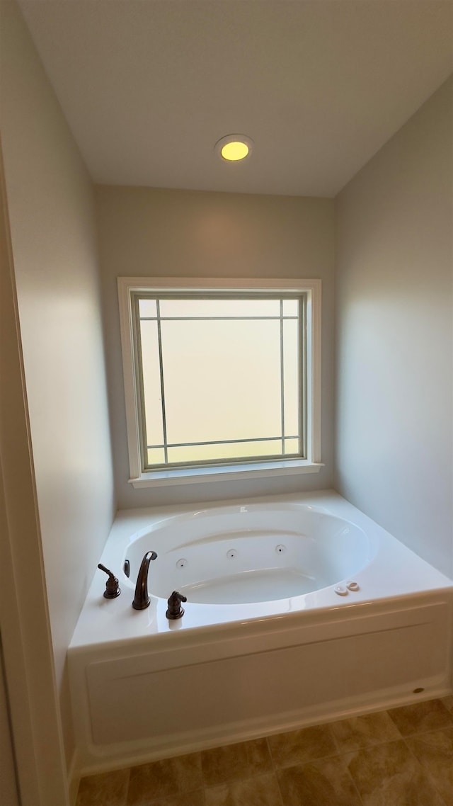 bathroom featuring a healthy amount of sunlight, a tub, and tile patterned flooring