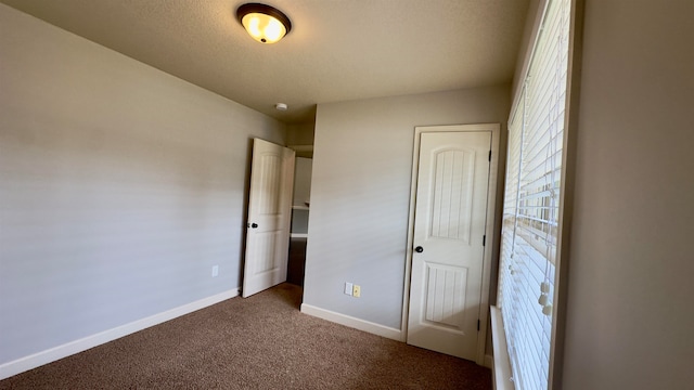 unfurnished bedroom featuring a closet, a textured ceiling, and carpet floors