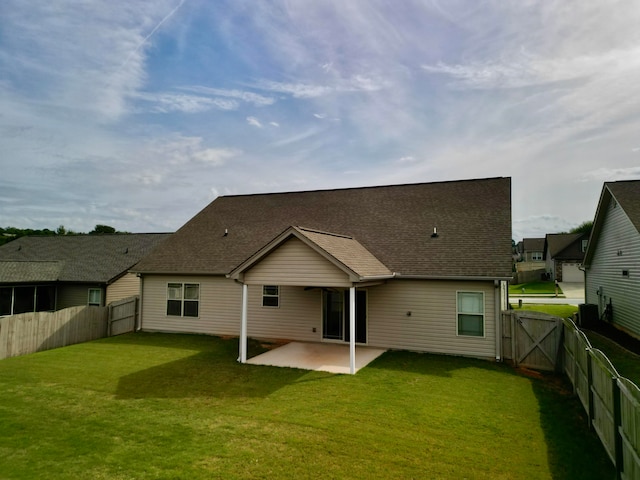 rear view of house featuring a yard and a patio