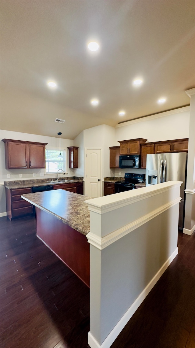 kitchen with a center island, decorative light fixtures, black appliances, dark wood-type flooring, and a kitchen breakfast bar