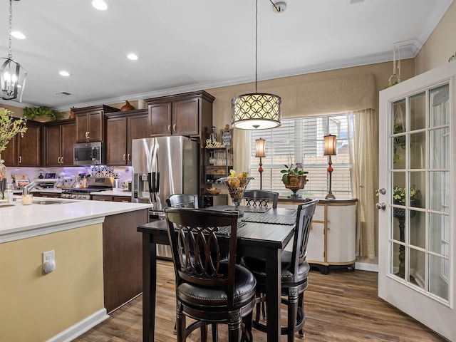 kitchen with appliances with stainless steel finishes, pendant lighting, and dark wood-type flooring