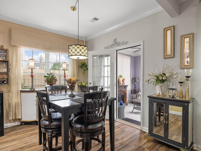 dining space with ornamental molding and wood-type flooring