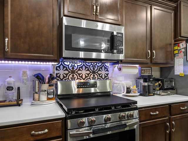 kitchen featuring backsplash, stainless steel appliances, and dark brown cabinets