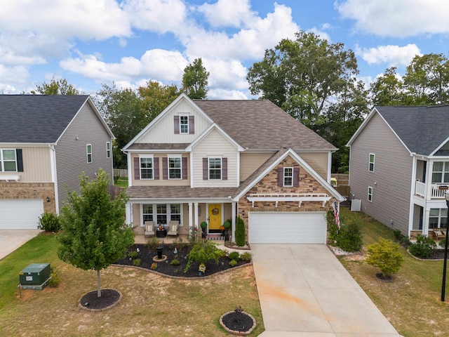 craftsman inspired home featuring a garage and a front lawn