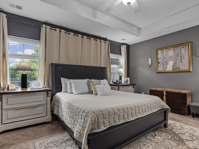 bedroom with ceiling fan, a raised ceiling, and carpet floors