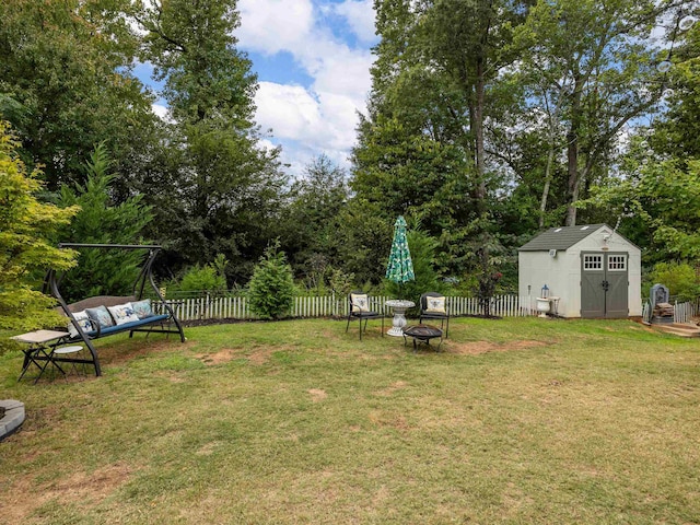 view of yard featuring a storage shed and an outdoor fire pit