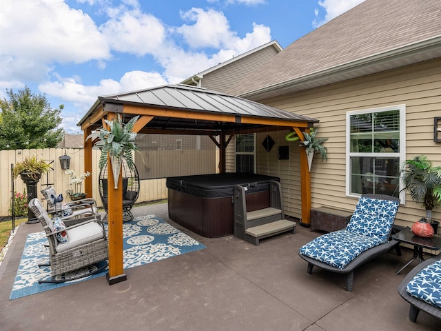 view of patio / terrace featuring a hot tub and a gazebo