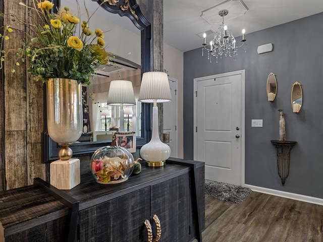 foyer entrance with an inviting chandelier and dark hardwood / wood-style floors