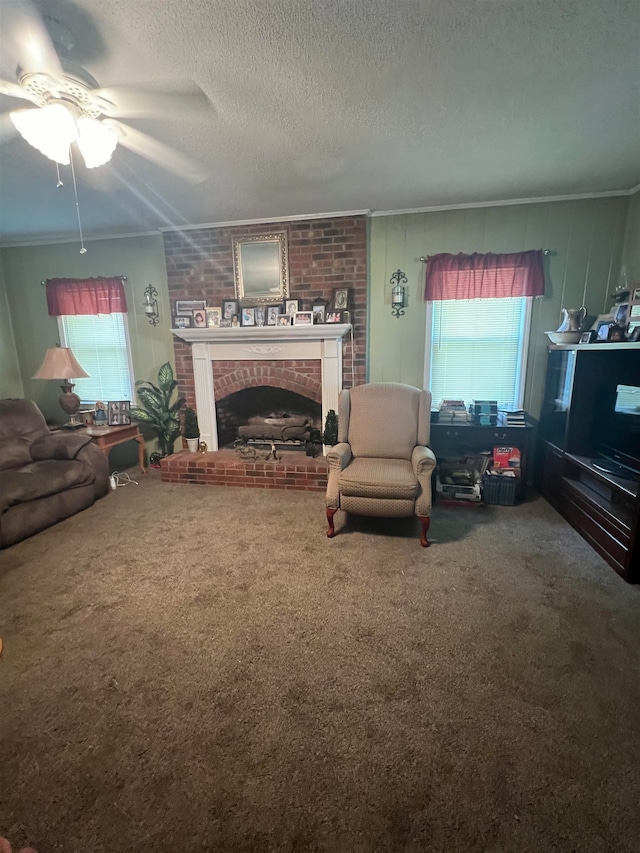 carpeted living room with ceiling fan, crown molding, a textured ceiling, and a brick fireplace