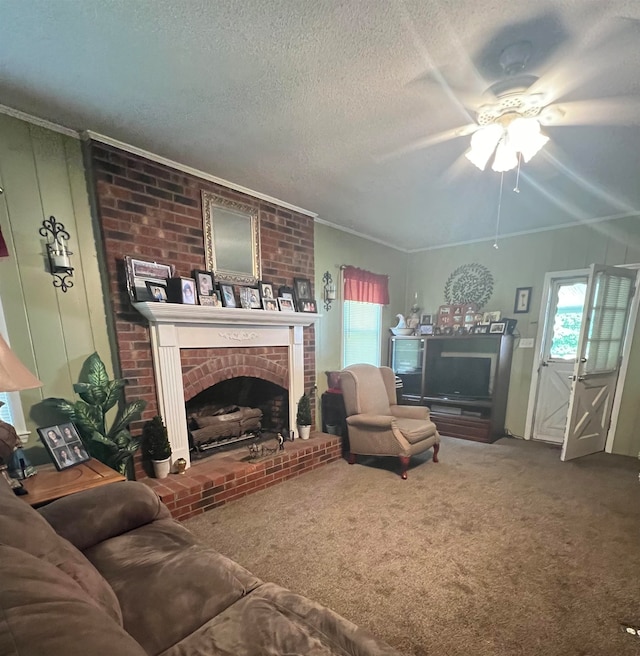 carpeted living room with a textured ceiling, crown molding, ceiling fan, and a fireplace