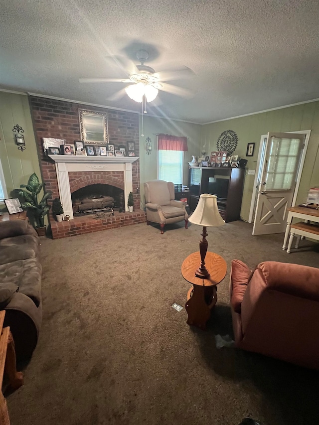 carpeted living room with a textured ceiling, ceiling fan, ornamental molding, and a fireplace