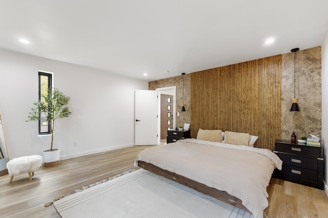 bedroom with wood-type flooring and wooden walls