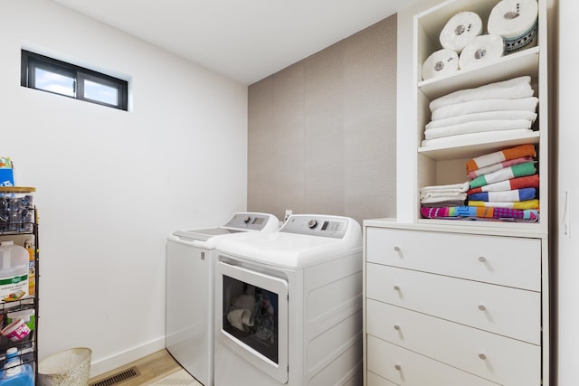 laundry area with light hardwood / wood-style flooring and washing machine and clothes dryer