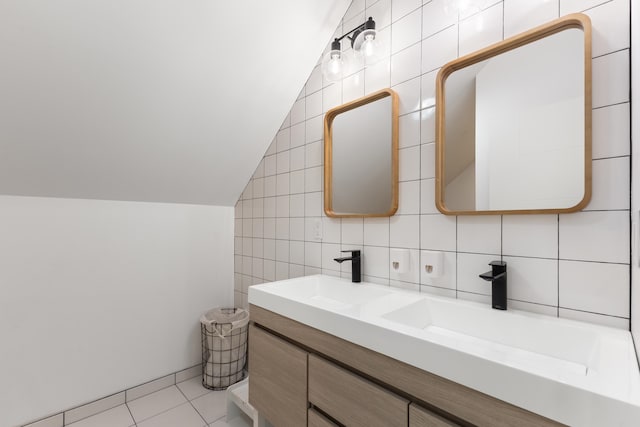 bathroom with vaulted ceiling, tile walls, vanity, and tile patterned flooring