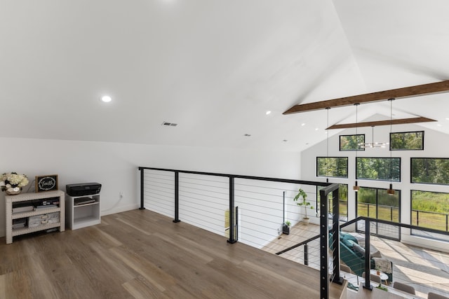 interior space featuring hardwood / wood-style flooring, an inviting chandelier, and vaulted ceiling with beams