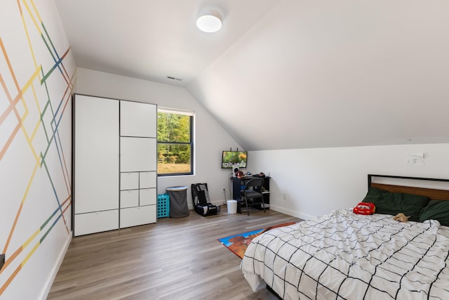 bedroom with lofted ceiling and hardwood / wood-style flooring