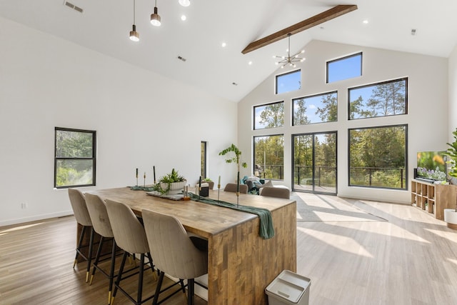 interior space featuring light wood-type flooring, plenty of natural light, a chandelier, and beamed ceiling