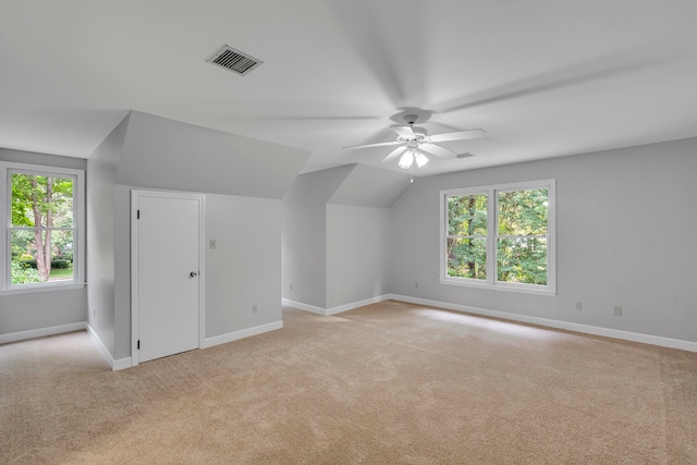 additional living space with light colored carpet, ceiling fan, and lofted ceiling