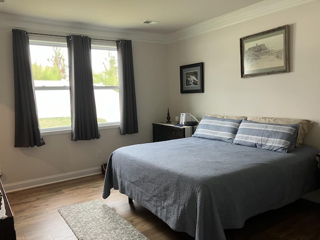 bedroom featuring hardwood / wood-style floors and ornamental molding