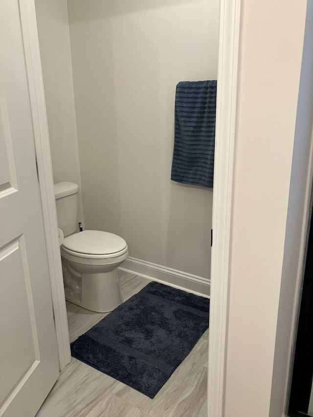 bathroom with toilet and hardwood / wood-style floors