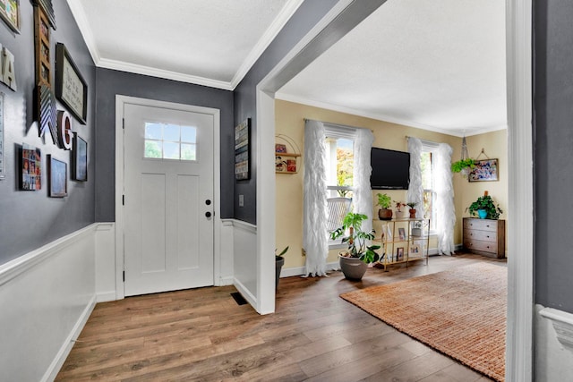 entrance foyer featuring wood-type flooring and ornamental molding