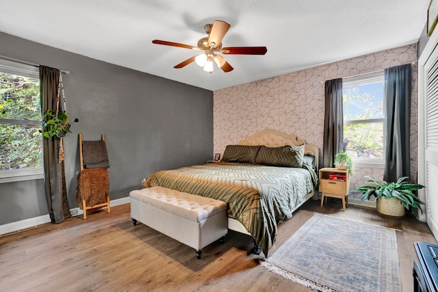 bedroom with wood-type flooring, multiple windows, and ceiling fan