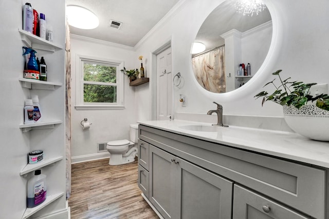 bathroom with wood-type flooring, vanity, toilet, and ornamental molding