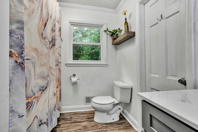 bathroom featuring wood-type flooring, vanity, crown molding, and toilet