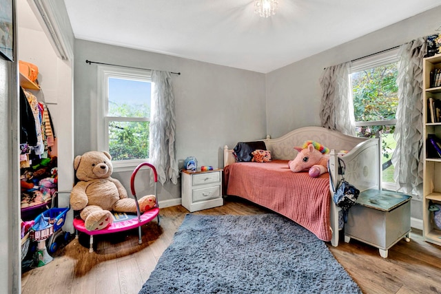 bedroom with multiple windows and hardwood / wood-style floors