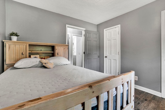 bedroom with a textured ceiling and dark hardwood / wood-style flooring