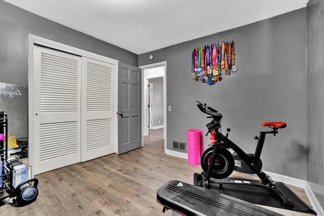 exercise area with a textured ceiling and hardwood / wood-style flooring