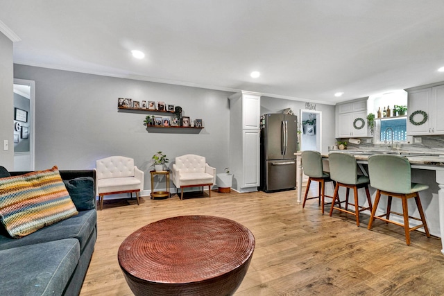 living room with crown molding and light hardwood / wood-style floors