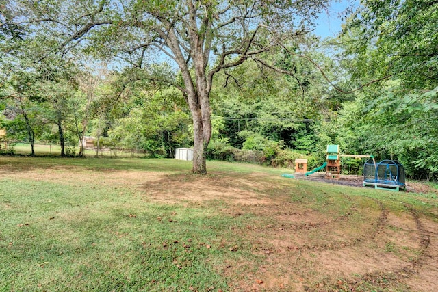 view of yard with a storage unit, a trampoline, and a playground