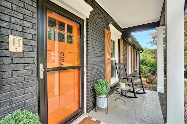 view of exterior entry featuring covered porch