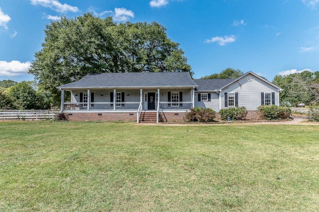 ranch-style house featuring a porch and a front yard