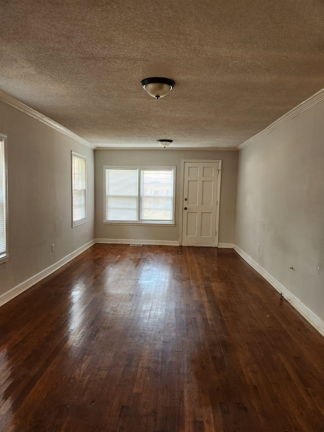 empty room featuring a textured ceiling, crown molding, and dark hardwood / wood-style flooring